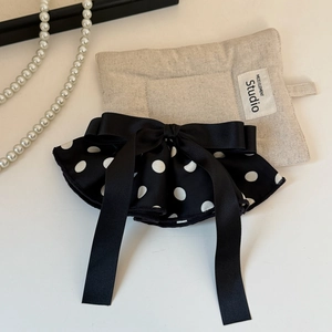 Macro shot of French style vintage black polka dot satin bow hair clip with long ribbon