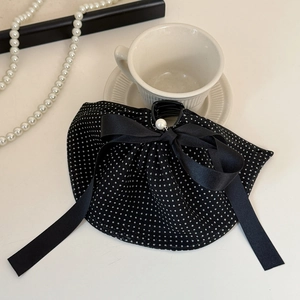 Détail de la pince à cheveux à pois avec rubans en satin et perle décorative