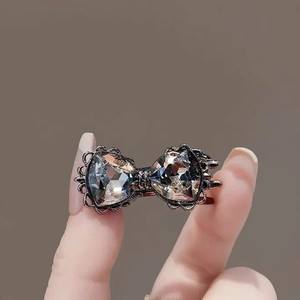 Détail d'une pince à cheveux avec nœud en strass et grands cristaux triangulaires