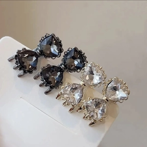 Gros plan d'élégantes boucles d'oreilles cœur en zircon avec cadres noirs et argentés