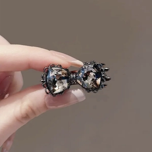 Gros plan détaillé d'une pince à cheveux vintage en forme de nœud avec strass gris fumé