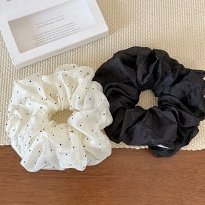 Chic black and white polka dot scrunchie set in soft satin with pearl luster