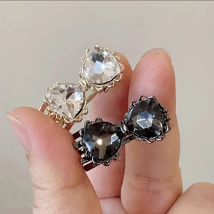 Gros plan de barrettes nœuds dorées et argentées avec des strass étincelants en forme de cœur