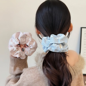 Set of pastel plaid scrunchies with white lace edges shown in a soft ponytail style