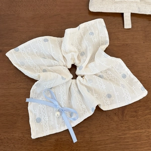 Detail von Spitzen-Haargummi mit blauen Punkten, Schleife und Perlenanhänger