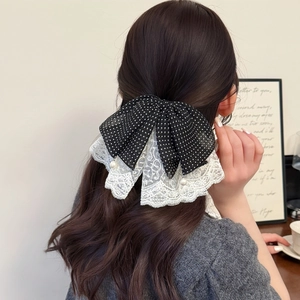 Elegant polka dot lace bow hair clip with pearls for women, shown on long wavy hair
