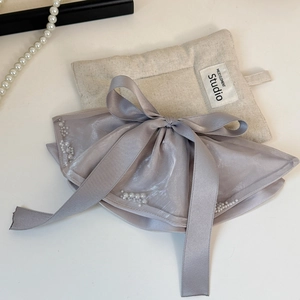 Detail of grey-purple satin bow hair clip with white pearl edges in elegant style