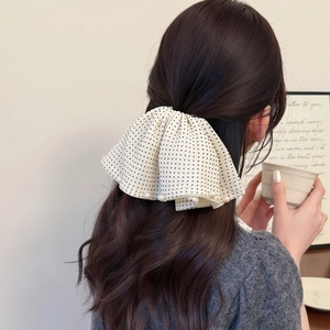 Detail of white chiffon hair claw with black polka dots and pearls on a ponytail