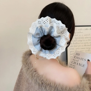 Detail of blue plaid and lace scrunchie on a hair bun with elegant vintage styling