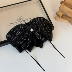 Vue détaillée de la pince à cheveux nœud noir à pois avec perle élégante et texture tulle