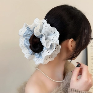 Detailed view of oversized gingham and white lace scrunchie on a hair bun