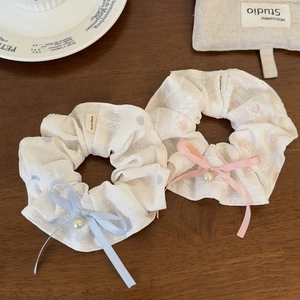French style scrunchies with white lace, pearls, and pastel ribbons on wood surface