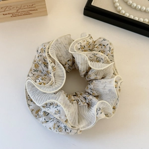 Detail of four-layer floral mesh hair scrunchie with yellow flowers and vintage pleats