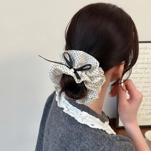 French polka dot bow scrunchie with pearl detail on a messy bun hairstyle