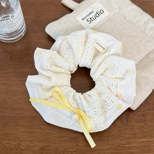 Détail chouchou en dentelle à pois avec nœud jaune et pendentif en perle élégant