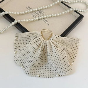 Detailed macro view of French chiffon polka dot hair claw with elegant faux pearls