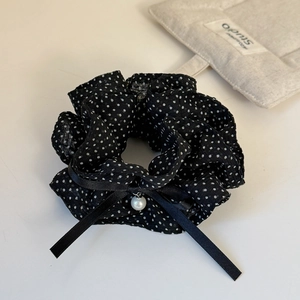Detail of French polka dot scrunchie with silk ribbon bow and elegant pearl pendant