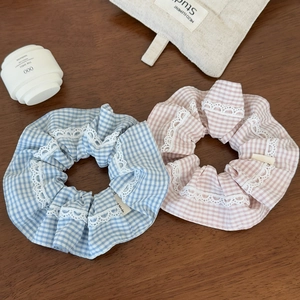 Close-up of light blue and pink gingham hair scrunchies with white lace edges
