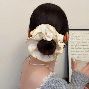 Détail d'un chouchou français surdimensionné avec bord jaune et texture de dentelle