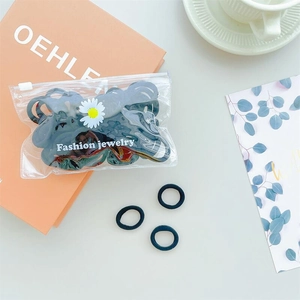 Close-up of high-elasticity black hair ties in a daisy-patterned jewelry zip bag