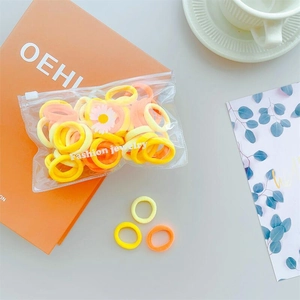 Close-up of colorful elastic hair bands with daisy charm in a clear fashion jewelry bag