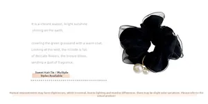 Close-up of black mesh scrunchie with two elegant faux pearl pendants and metal charms