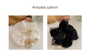 Detail of chiffon scrunchies in white and black featuring elegant double pearl pendants