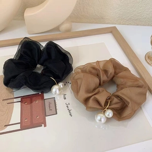 Detail of French chiffon scrunchies in black and brown with elegant pearl accents