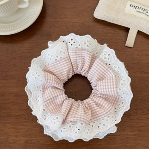 Detail of pink plaid fabric and white lace trim on the sweet scrunchie accessory