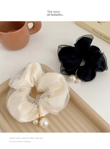 Detail of elegant chiffon scrunchies with white pearls and golden ring accents in two colors