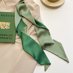 Close-up of green silk scarf featuring a double-sided emerald satin and plaid pattern