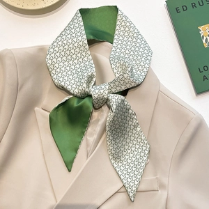 Elegant green silk scarf with star pattern styled on a beige blazer fashion accessory