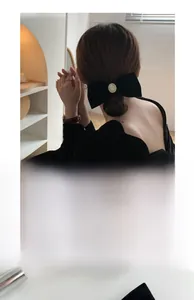 Elegant black velvet bow hair clip with a radiant oval pearl detail for women