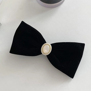 Elegant black velvet bow hair clip with central pearl ornament for women's hairstyling