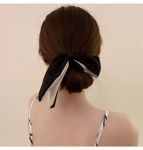 Detail of a large double-layer black and white bow hair scrunchie on hair
