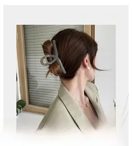 Side view of a large grayish green translucent hair claw clip on an elegant hairstyle