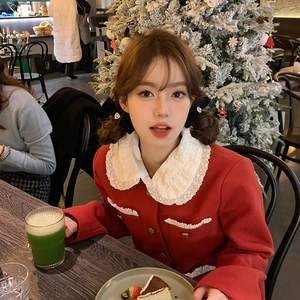 Elegant red tweed jacket with white lace collar and gold buttons in a cafe setting