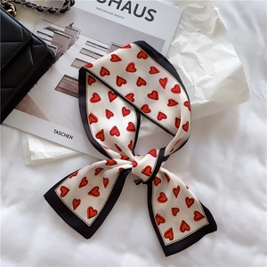 Detail of elegant French silk ribbon with red heart print and black contrast border
