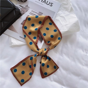 Detail of mustard yellow silk ribbon scarf with blue polka dots and a red border