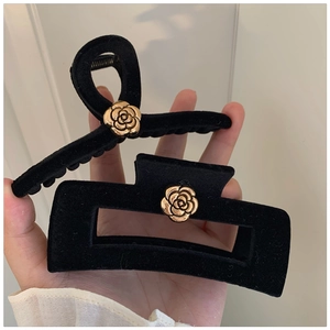 Set of two black velvet hair claws featuring golden camellia flowers for elegant styling