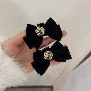 Set of two black velvet camellia bow hair clips with elegant gold flower detailing