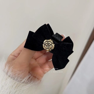 Elegant black velvet bow hair clip with a golden camellia flower center for women