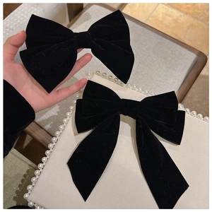 Close-up of vintage black velvet bow hair clips featuring long ribbons and elegant textures