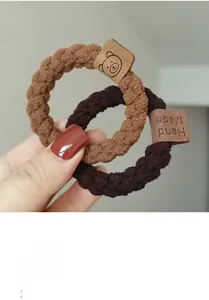 Détail de chouchous en tricot avec étiquettes en cuir d'ours en marron et beige