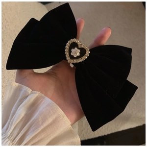 Detailed macro view of black velvet bow hair claw with camellia heart and crystals