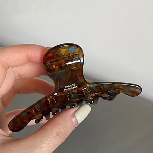 Dettaglio della molletta per capelli in acetato tartarugato con scritta France