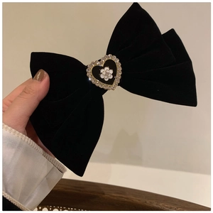 Detailed close-up of velvet bow hair claw featuring a heart camellia pearl ornament