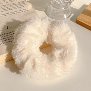 Nahaufnahme eines flauschigen beigen Plüsch-Haargummis mit weicher Textur für Herbst-Styles