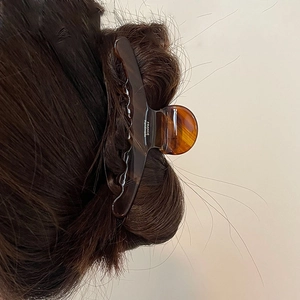 Elegante molletta per capelli in acetato ambrato con scritta France Handmade su modella