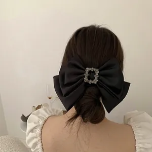 Elegant large black satin bow hair clip with square rhinestone center for women